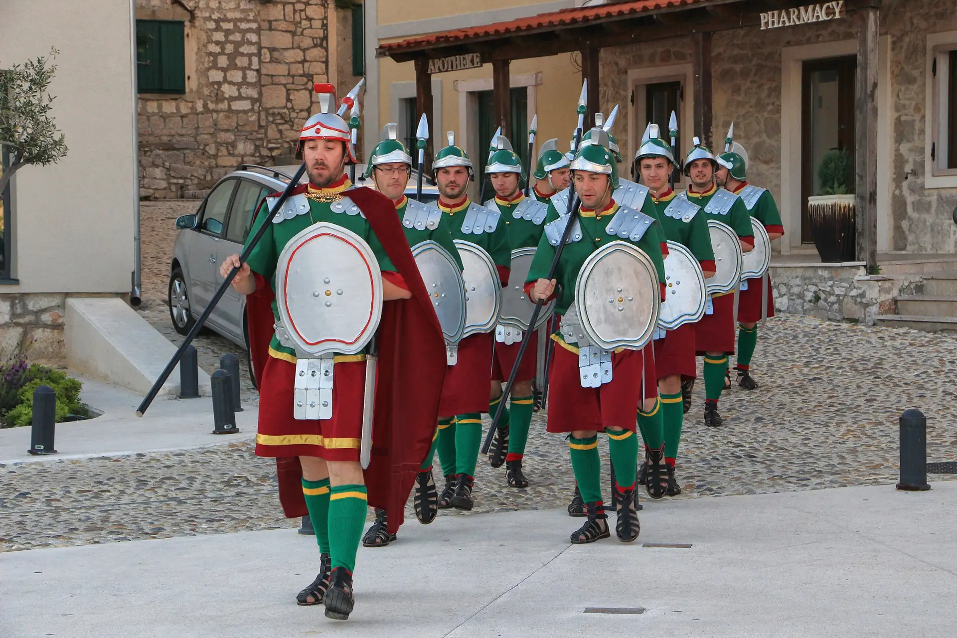 Slika prikazuje Čuvare Božjeg greba u centru Betine – sudionike vjerske procesije odjevene u posebne odore koje je izradio lokalni krojač Roman Magazin. Ovaj tradicionalni obred, koji se održava 6. kolovoza, duboko je povezan s pomorskom i duhovnom baštinom mjesta. Mještani nose sliku Božjeg greba kroz mjesto, uz procesiju drvenih brodica i kulturne sadržaje koji dodatno ističu identitet Betine.